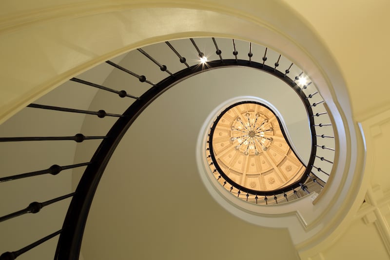 A dramatic spiral staircase leads up to the property's first floor. Photo: Sotheby’s International Realty
