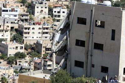 A wing of a building is seen collapsed in Salt, Jordan, Sunday, Aug. 12, 2018. Jordanian search teams pulled the bodies of three suspected militants from the rubble of their hideout, a government official said Sunday, hours after assailants opened fire and set off explosions that killed three members of the security forces trying to storm the building. (AP Photo/Raad Adayleh)