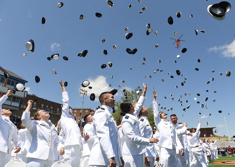 US coastguard ensigns toss their caps in celebration at a commencement ceremony in New London, Connecticut. AP