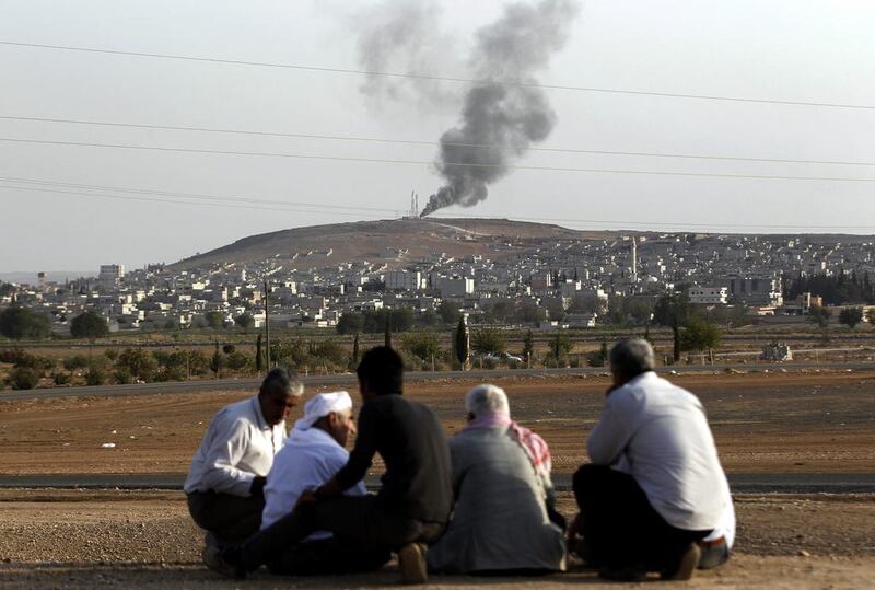 People watch while smoke rises from Syria's Kobani city on the Turkish-Syrian border, near Sanliurfa on October 3. EPA