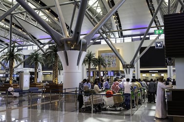 Passengers queue at the airline check-in desks inside the passenger terminal at the airport in Muscat, Oman. Bloomberg
