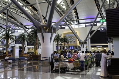 Passengers queue at the airline check-in desks inside the passenger terminal at Muscat International Airport in Muscat, Oman, on Monday, May 7, 2018. Being the Switzerland of the Gulf served the country well over the decades, helping the sultanate survive, thrive and make it a key conduit for trade and diplomacy in the turbulent Middle East. Photographer: Christopher Pike/Bloomberg