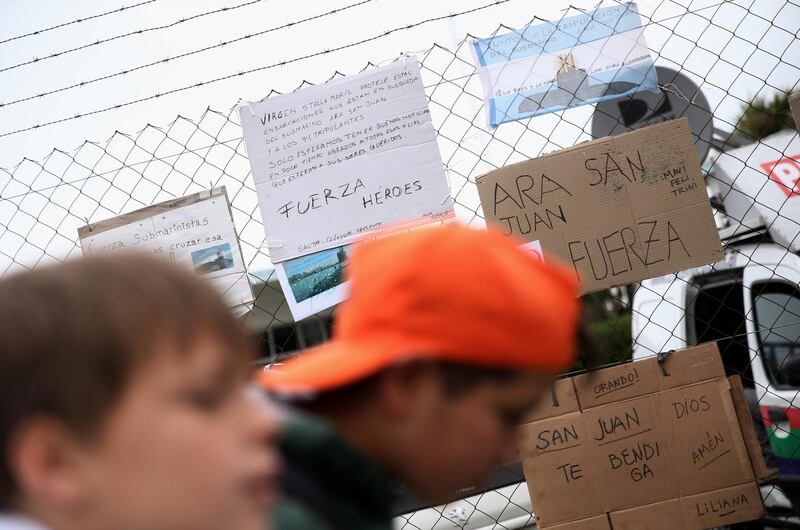 Children walk by signs in support of the 44 crew members of the ARA San Juan submarine missing at sea, placed on a fence at the Argentine Naval Base where it sailed from, in Mar del Plata, Argentina November 20, 2017. REUTERS/Marcos Brindicci