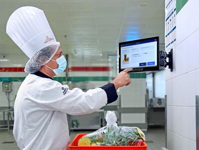 A chef at Emirates Flight Catering uses the Winnow system to log food being thrown away. Emirates