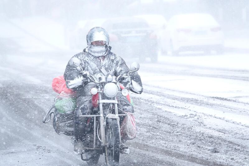 A motorcyclist rides amid snow in Dalian, Liaoning province, China. Reuters