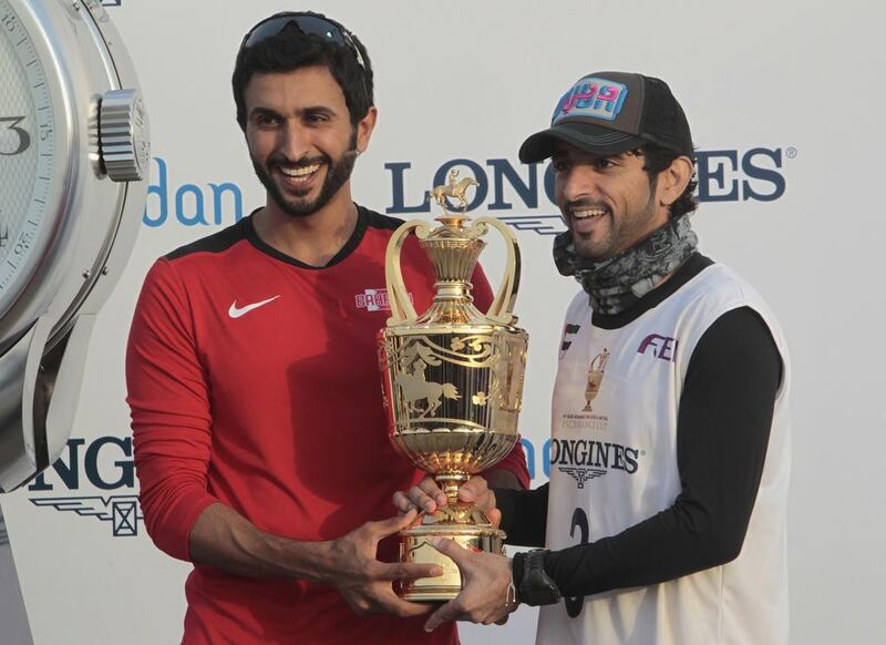 Sheikh Nasser bin Hamad Al Khalifa of Bahrain presents the trophy to Sheikh Hamdan  after his win.