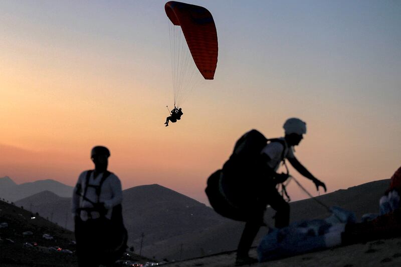 Members of the Sulaymaniyah paragliding team launch at sunset from Mount Azmar to glide over the city of Sulaymaniyah in north-eastern Iraq's autonomous Kurdistan region.