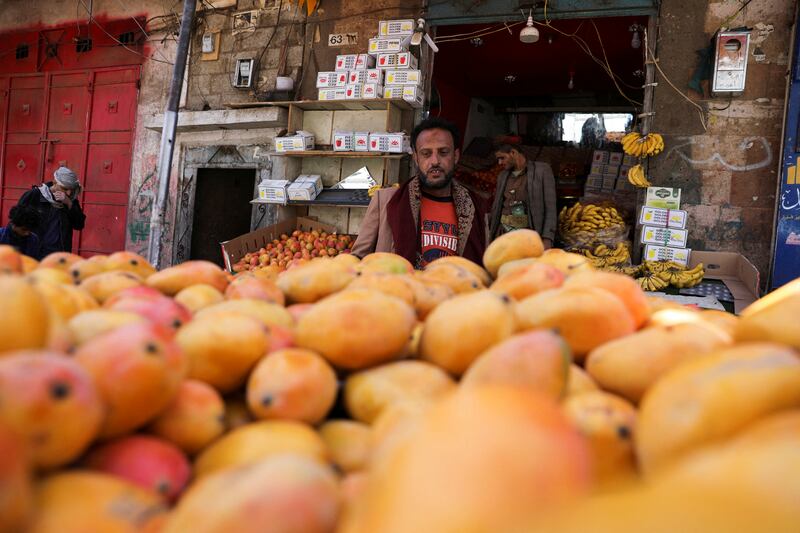 A man looks at mangoes in a street stall in Sanaa.