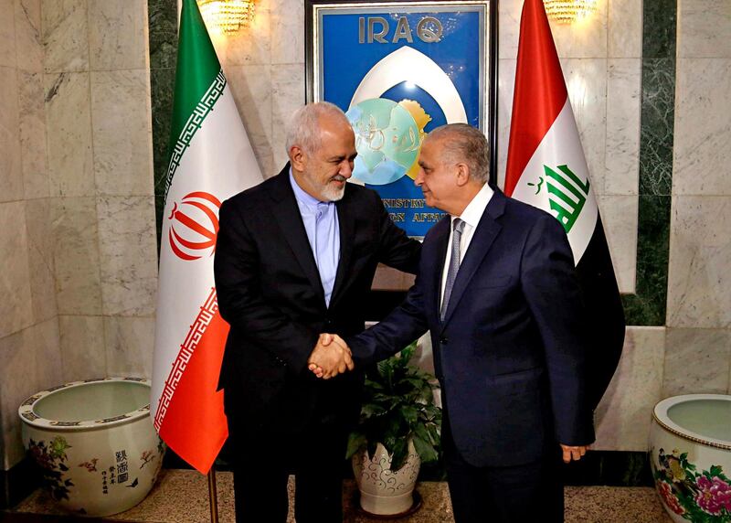 Iraqi Foreign Minister Mohamed Alhahkim, right, shakes hands with his visiting Iranian counterpart Mohammad Javad Zarif at the Ministry of Foreign Affairs Building in Baghdad, Iraq, Sunday, March 10, 2019. Iranian President Hassan Rouhani is planning to make his first official visit to Iraq Monday, March 11, 2019, as he faces mounting pressure from hard-liners at home in the wake of the unravelling of the nuclear deal under the Trump administration. (AP Photo/Hadi Mizban)