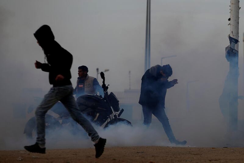 Palestinians react to tear gas fired by Israeli troops during a protest at the Israeli-Gaza border fence, east of Gaza City on March 29, 2019. Reuters