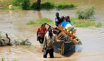 FILE PHOTO: Residents use a boat to carry their belongings through the waters after their homes were flooded as the River Nzoia burst its banks and due to heavy rainfall and the backflow from Lake Victoria, in Budalangi within Busia County, Kenya May 3, 2020. REUTERS/Thomas Mukoya/File Photo
