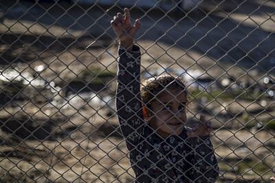 A child smiles from behind a fence at the Kurdish-run al-Hol camp for the displaced in the al-Hasakeh governorate in northeastern Syria on January 14, 2020, at the section reserved for Iraqis and Syrians. 
 Particularly difficult living conditions in the camp reportedly resulted in the death of more than 517 people, including 371 children in 2019. Foreign women and children affiliated with the Islamic State(IS) were mainly sent to al-Hol when they were evacuated from the last stronghold of the jihadist group, reconquered by the Kurdish forces in March 2019.  / AFP / DELIL SOULEIMAN
