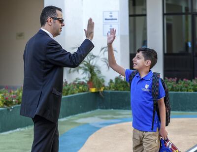 Abu Dhabi, U.A.E., September 2, 2018. 
 Pupils heading to school for the first day after the summer break at the Pearl Academy School on Muroor Road.  High fives before going to class.  Mustafa-9, Grade 5, gives a high five to his father, Barraq before class.
Contact: Victor Besa / The National
Section:  NA
Reporter:  Anam Rizvi