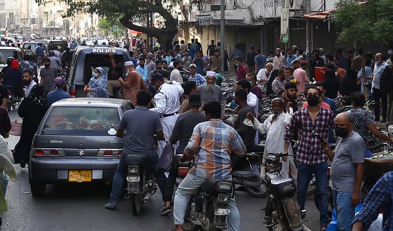 People rush to leave markets and roads after the government announced restrictions on staying indoors after 8pm during a third wave of the coronavirus pandemic in Karachi, Pakistan. EPA