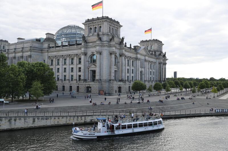 epa08542024 An excursion boat passes the German parliament Bundestag building on the Spree in Berlin, Germany, 12 July 2020.  EPA/HAYOUNG JEON