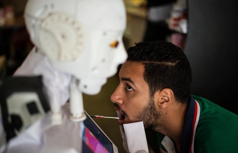 A robot designed by Egyptian engineer Mahmoud El Koumy collects swab for coronavirus testing, in Tanta, about 100 kilometres north of Cairo, Egypt. EPA
