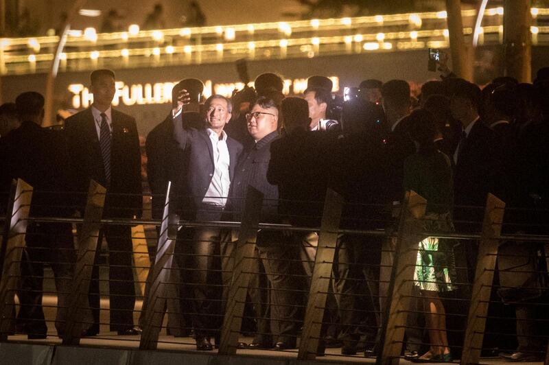 SINGAPORE - JUNE 11: Singapore Minister for Foreign Affairs Vivian Balakrishnan (L) takes a selfie with North Korean leader Kim Jong-un walks along the Jubillee bridge during a tour of some of the sights on June 11, 2018 in Singapore. The historic meeting between U.S. President Donald Trump and North Korean leader Kim Jong-un has been scheduled in Singapore for June 12 as a small circle of experts have already been involved in talks towards the landmark summit in the city-state.  (Photo by Chris McGrath/Getty Images)