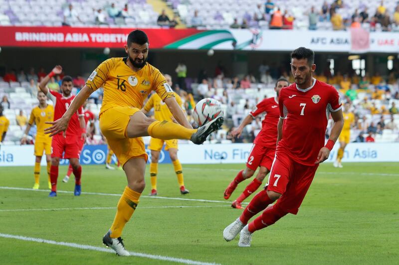 Australia's defender Aziz Behich, left, shoots the ball next to Jordan's forward Yousef AL-Rawashdeh during the AFC Asian Cup group B soccer match between Australia and Jordan at Hazza bin Zayed stadium in Al Ain, United Arab Emirates, Sunday, Jan. 6, 2019. (AP Photo/Hassan Ammar)