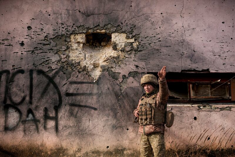 A Ukrainian serviceman next to a shelled building in the east of the country. AP