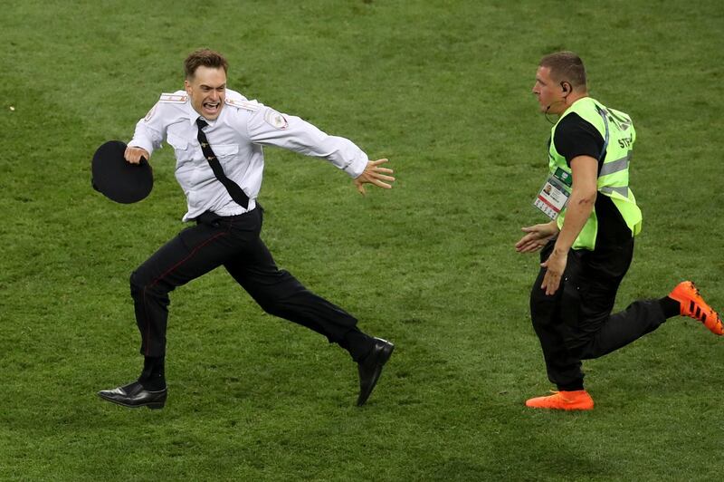 FILE - In this Sunday, July 15, 2018 file photo, Pyotr Verzilov invading the pitch, runs away as a steward tries to stop him during the France and Croatia 2018 World Cup final match in the Luzhniki Stadium in Moscow, Russia. Russian news reports say Verzilov a member of Russian punk protest group Pussy Riot has been hospitalized in grave condition for what could be a possible poisoning. (AP Photo/Thanassis Stavrakis, File)