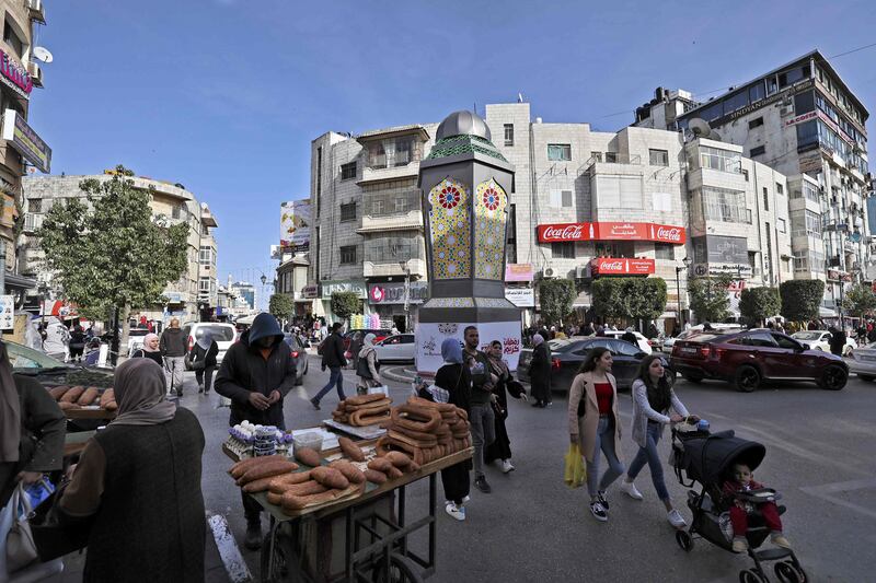 Palestinians walk by a giant decorative Ramadan lantern in the West Bank city of Ramallah. AFP