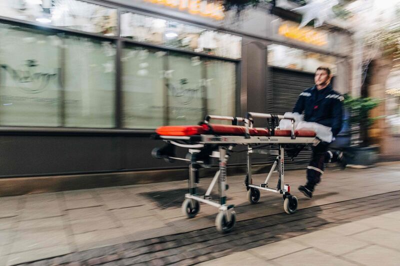 An emergency worker runs with a stretcher towards the scene of a shooting near the Christmas market in Strasbourg. AFP