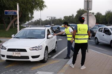 Emirates Red Crescent volunteers distribute iftar boxes and water to motorists waiting at red lights in the Mushrif area of Abu Dhabi. Ravindranath K / The National