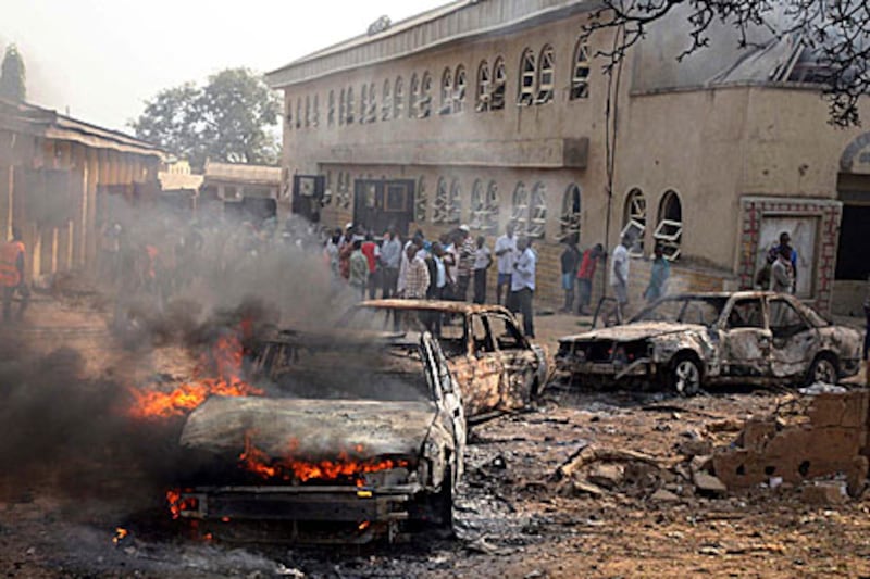 A car burns at the scene of a militant attack on a church outside the Nigerian captial of Abuja. At least 27 people were killed in five bomb attacks claimed by Boko Haram.