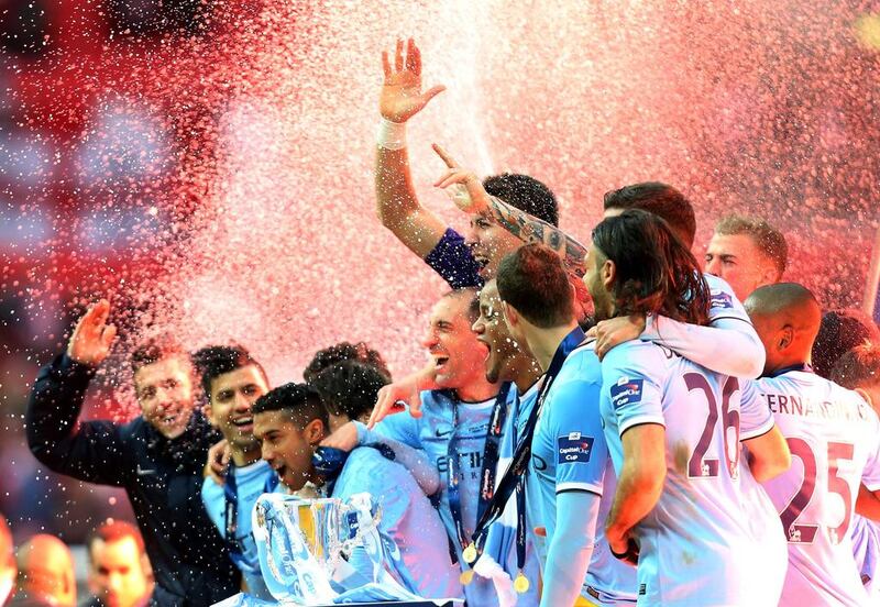 Manchester City players celebrate with the trophy after their League Cup final victory. Scott Heppell / AP