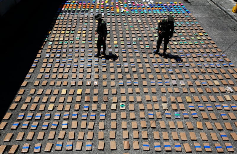Police officers walk among packages of seized cocaine at the Pacific port of Buenaventura, Colombia. AP Photo