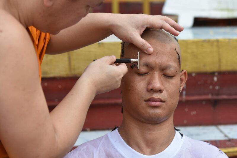 A monk shavse the hair and eyebrows of Chantawong. AFP