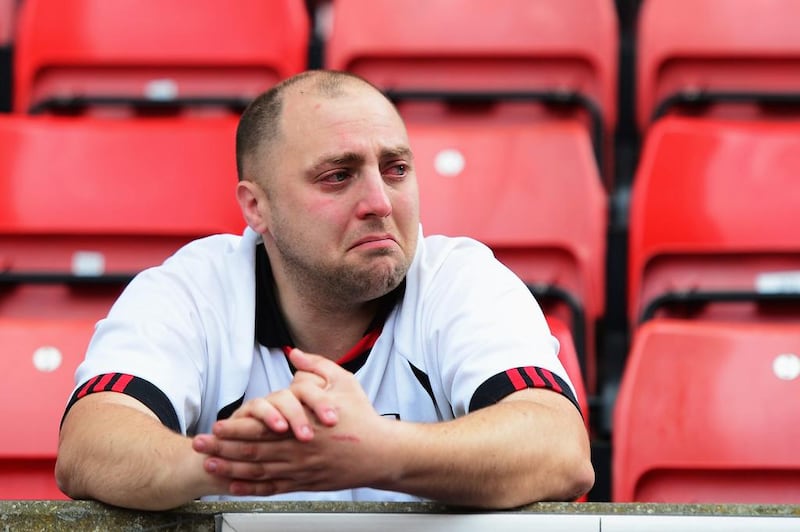A Fulham fan reacts as his side were also relegated following their defeat in the English Premier League to Stoke City. Jamie McDonald / Getty Images