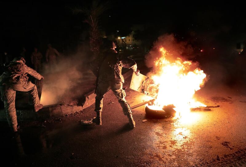 Lebanese soldiers remove tires that set on fire by protesters, during a protest against deteriorating living conditions and strict coronavirus lockdown measures, in Tripoli, Lebanon, Friday, Jan. 29, 2021. AP