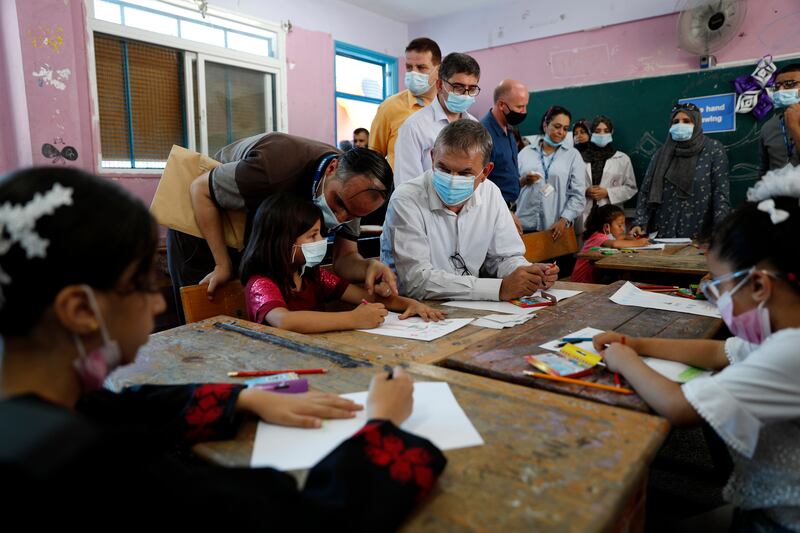 In this July 4, 2021, file photo, Philippe Lazzarini, center, commissioner-general of United Nations Relief and Works Agency for Palestine Refugees in the Near East (UNRWA), sits with students participating in an UNRWA summer camp at Beach Preparatory School for girls, in the Shati refugee camp. AP