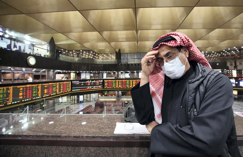 A Kuwaiti trader wearing a protective mask follows the market at the Boursa Kuwait stock exchange in Kuwait City on March 1, 2020. - Boursa Kuwait decided to close the main trading hall due to the COVID-19 coronavirus disease developments. Stock markets in the oil-rich Gulf states plunged on March 1 over fears of the impact of the coronavirus, which also battered global bourses last week. All of the seven exchanges in the Gulf Cooperation Council (GCC), which were closed the previous two days for the Muslim weekend, were hit as oil prices dropped below $50 a barrel. The region's slide was led by Kuwait Boursa, where the All-Share Index fell 10 percent, triggering its closure. Kuwait's bourse was closed for most of last week for national holidays. (Photo by YASSER AL-ZAYYAT / AFP)