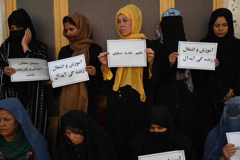 Afghan women hold placards reading in Dari 'A Muslim can't go against women's education and work', during a protest in Mazar-e-Sharif on 16 August 2023. EPA