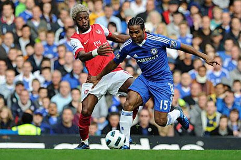 Chelsea’s Florent Malouda, right, fends off a challenge from Arsenal’s Alex Song.