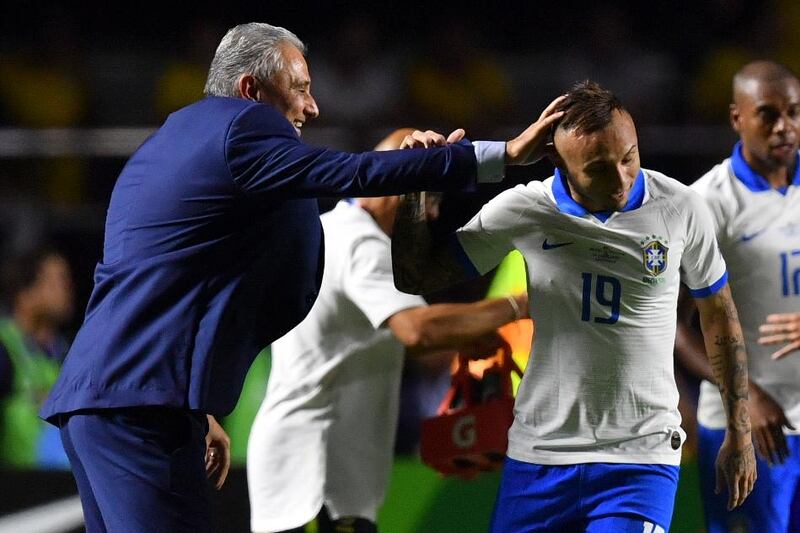 Brazil's Everton Soares celebrates with coach Tite after scoring against Bolivia. AFP