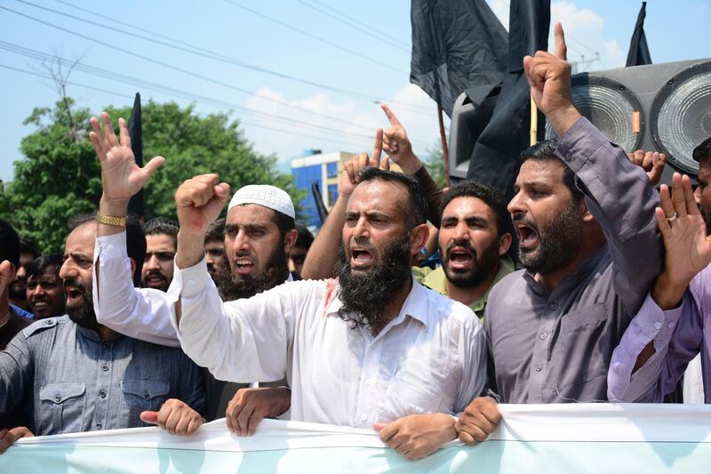 Pakistani Kashmiris protest against India and express support and solidarity with Indian Kashmiri people in their peaceful struggle for their right to self-determination, in Muzaffarabad, capital of Pakistani Kashmir, Monday, Aug. 5, 2019. India's government has revoked disputed Kashmir's special status by a presidential order as thousands of troops patrolled and internet and phone services were suspended in the region where most people oppose Indian rule. (AP Photo/M.D. Mughal)