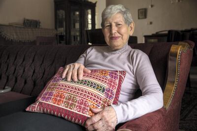 Samia Khoury, a Palestinian Christian, as she holds a pillow her mother embroidered as she sits in the living room of  her home in the east Jerusalem neighbourhoud of Beit Hanina recalling how she helped save Palestinian refugees that had fled from their homes in 1948. (Photo by Heidi Levine/For The National).