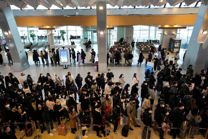 Passengers queue to board planes in Seoul. AP Photo