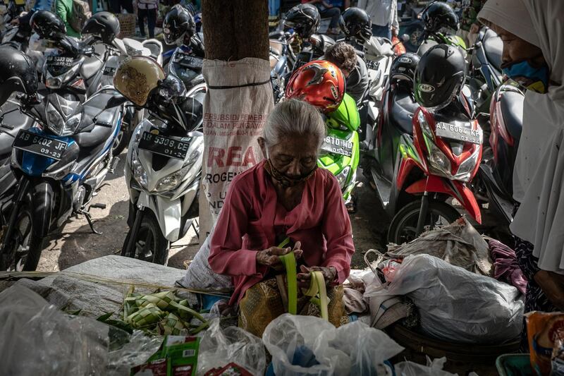 An elderly woman seller weaves a fresh coconut leaves used to make traditional rice cakes known as 'Ketupat' at traditional market in preparation of the upcoming Eid al-Fitr holiday in Yogyakarta, Indonesia. Getty Images