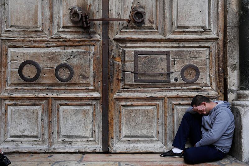 epaselect epa06566473 A visitor prays outside the closed gate to the Church of the Holy Sepulcher in the Old City quarter of Jerusalem, 26 February 2019. Christian leaders in Jerusalem announced on 25 February the closure of the church until further notice, following a dispute with the Jerusalem municipality over tax matters and a government bill relating to land belonging to the church.  EPA/ABIR SULTAN
