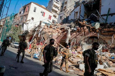 Lebanese soldiers walk past a partially destroyed building in Beirut. The World Bank says Lebanon needs up to $760 million until December 2020, and $1.46 billion in 2021 to address its most pressing needs after the explosion. AFP 