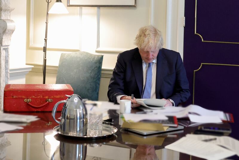 Boris Johnson reads the findings of the Sue Gray report into  gatherings on government premises while Covid-19 restrictions were in place, in his office in No 10, Downing Street in May 2022. Photo:  Downing Street