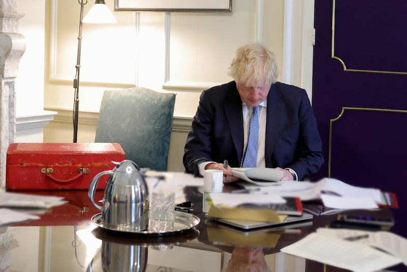 Mr Johnson reads the long-awaited report by senior civil servant Sue Gray into the Downing Street party scandal, in his Downing Street office in May 2022. Photo: Downing Street
