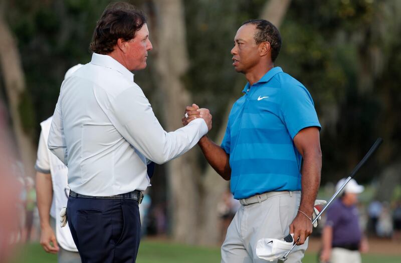 FILE - In this May 10, 2018, file photo, Phil Mickelson, left, and Tiger Woods shake hands after the first round of the Players Championship golf tournament, in Ponte Vedra Beach, Fla. Golf.com is reporting that Phil Mickelson and Tiger Woods are contemplating a $10 million winner-take-all exhibition match. The report says Mickelson was hopeful the match would have taken place on July 3 in Las Vegas, except that negotiations with a television network and corporate support could not be worked out in time. Mickelson says they are working on a different date.Woods' agent, Mark Steinberg, declined to comment on the report.(AP Photo/Lynne Sladky, File)