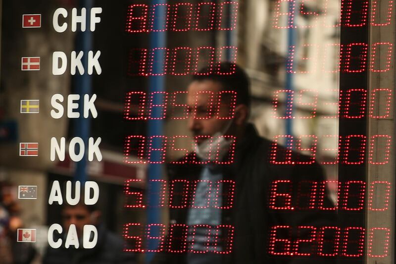 A man is reflected at a foreign currency board in a currency exchange shop, in Istanbul. AP Photo