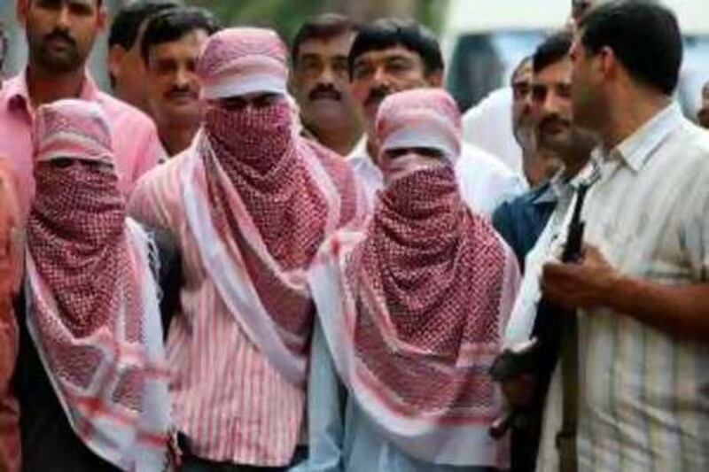 Delhi Police personnels present to the media suspected Indian Mujahideen (IM) militants Shakeel (L), Shakir Nishar (2L) and Zia-ur-Rehman (3L) in New Delhi on September 21, 2008.  Indian police arrested three more suspected militants over a series of bombings across the country that have left more than 140 people dead. The police said the three men belonged to the Indian Mujahideen, which has claimed responsibility for serial blasts in several cities including attacks in New Delhi on September 13.     AFP PHOTO/Prakash SINGH *** Local Caption ***  317756-01-08.jpg