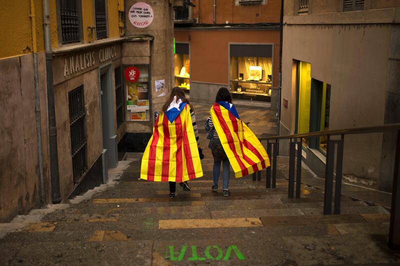 Women with "esteladas," or Catalonia independence flag, walk along the old quarter in Girona, Spain, Monday, Oct. 2, 2017. Catalonia's government will hold a closed-door Cabinet meeting Monday to discuss the next steps in its plan to declare independence from Spain following a disputed referendum marred by violence. Regional officials say the vote, which Spain insists was illegal and invalid, shows that a majority favor secession. (AP Photo/Francisco Seco)